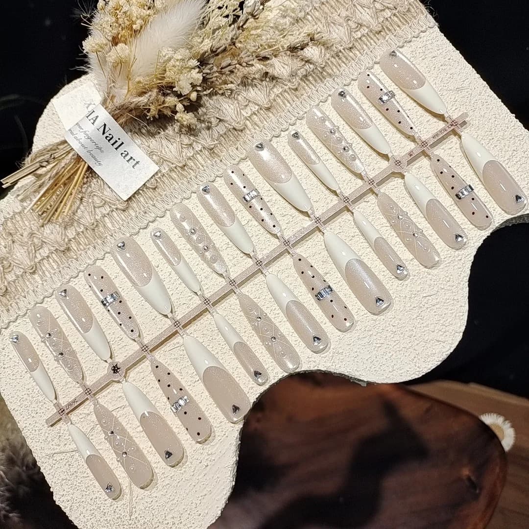 Mlečno beli nalepni nohti z velikimi okraski, učinek mačjega očesa