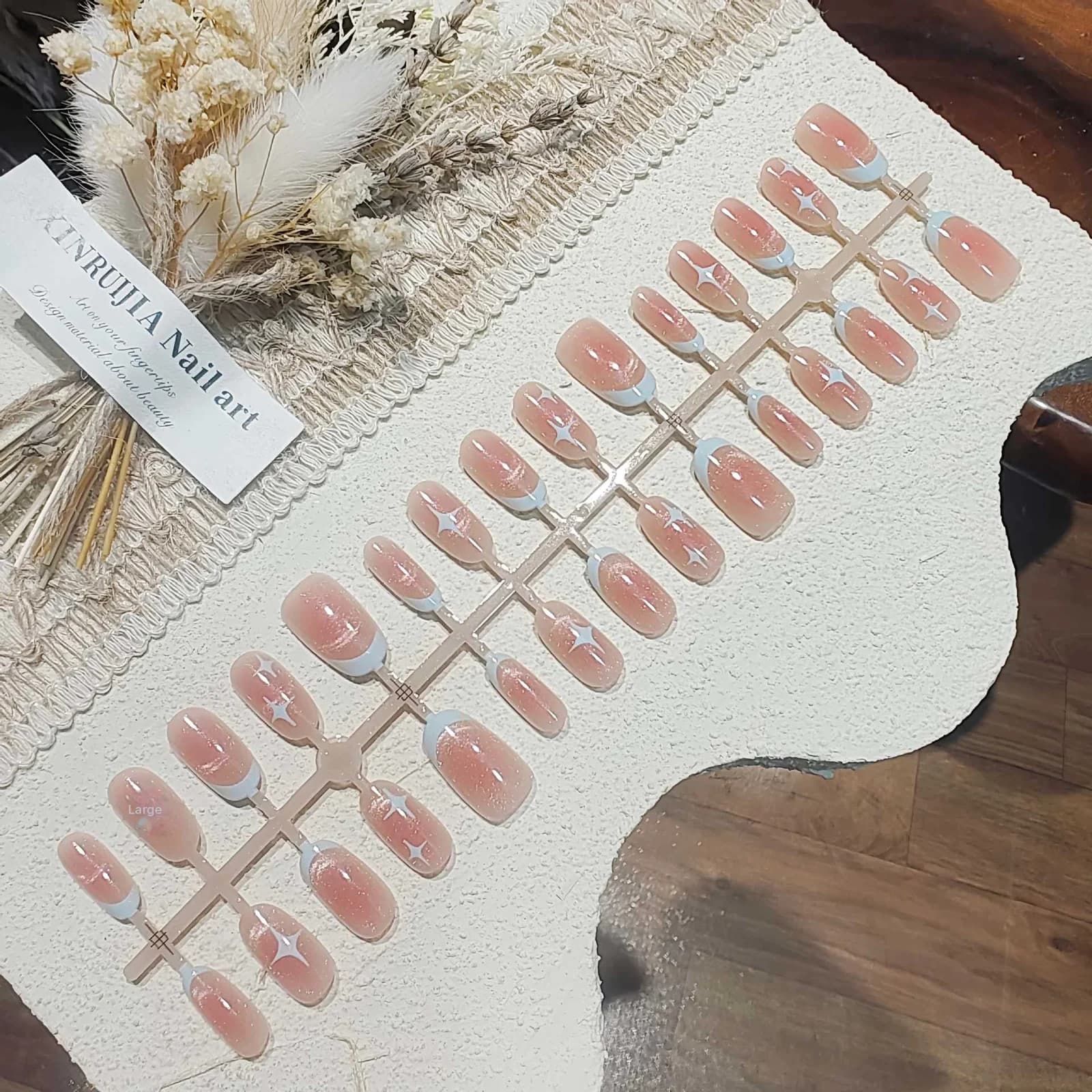 Kratki ovalni umetni nohti mačje oči z rožnatim zvezdnatim nebom